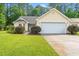 Charming yellow single-story home with a manicured lawn and attached two-car garage at 396 Mckendree Ln., Myrtle Beach, SC 29579