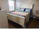 Bedroom featuring a white bed frame, colorful quilt, and natural light from the window at 401 Quinta St., Longs, SC 29568