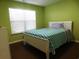 Bright bedroom featuring green walls and a well-lit space with a cozy bed and coordinated bedding at 401 Quinta St., Longs, SC 29568