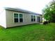 Back exterior showcasing the siding and well-maintained yard space at 401 Quinta St., Longs, SC 29568