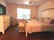 Bright main bedroom featuring a decorative bed frame, hardwood floors, and a large window at 401 Quinta St., Longs, SC 29568