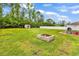 Large backyard with lush green grass, a fire pit, and a shed surrounded by mature trees at 408 Carmello Circle, Conway, SC 29526