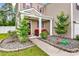 Inviting front porch with red seating, decorative plants, and a well-manicured lawn at 408 Carmello Circle, Conway, SC 29526