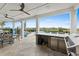 Spacious covered patio with ceiling fans, outdoor kitchen, and outdoor living space overlooking a serene river at 433 Saint Julian Ln., Myrtle Beach, SC 29579