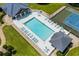Aerial view of community pool with ample lounge chairs and adjacent tennis court at 4648 Lightkeepers Way # 39A, Little River, SC 29566
