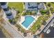 Aerial view of community pool featuring lounge chairs, palm trees, and nearby docks at 4648 Lightkeepers Way # 39A, Little River, SC 29566