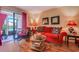 Comfortable living room with a red sofa, wicker table, and access to an outdoor patio at 510 Fairwood Lakes Dr. # 15-I, Myrtle Beach, SC 29588