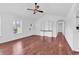 Open living room area with hardwood floors, a ceiling fan, bright white walls, and natural light at 553 Fox Chase Dr., Conway, SC 29527