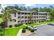 Three-story condo building with lush landscaping and well-maintained parking area at 562 Blue Stem Dr. # 54-F, Pawleys Island, SC 29585