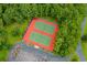 Aerial view of red and green community tennis courts surrounded by trees and parking at 562 Blue Stem Dr. # 54-F, Pawleys Island, SC 29585
