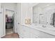 Modern bathroom featuring double sinks, wood-look tile floors, and a view of the walk-in closet at 563 Sea Sparrow St. # 563, Myrtle Beach, SC 29588