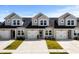 Charming townhomes featuring attached garages, modern design, and inviting curb appeal under a bright blue sky at 563 Sea Sparrow St. # 563, Myrtle Beach, SC 29588