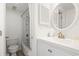 Bright bathroom featuring a white vanity, a round mirror and shower-tub with white tiling at 5905 S Kings Highway # 1206-C, Myrtle Beach, SC 29575
