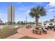 Outdoor picnic area with tables, grills, and palm trees near the water at 5905 S Kings Highway # 1206-C, Myrtle Beach, SC 29575