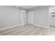 A bright bedroom with gray walls, wood floor, closet, and an en-suite bathroom at 601 Mitchell Dr. # 207, Myrtle Beach, SC 29577