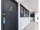 Condominium entryway featuring a black door marked with the gold number 207 and hallway with windows at 601 Mitchell Dr. # 207, Myrtle Beach, SC 29577