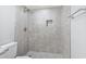 Walk-in shower featuring grey tile surround, a shower head, built-in niche, and decorative tile flooring at 601 Mitchell Dr. # 207, Myrtle Beach, SC 29577