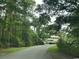 Scenic driveway leading to a cozy home surrounded by lush trees at 601 Putters Ln. # H209, Little River, SC 29566