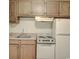Cozy kitchen featuring classic wood cabinets, a white refrigerator, and an electric range at 601 Putters Ln. # H209, Little River, SC 29566