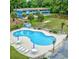 Inviting pool area with plenty of lounge chairs, tables, and greenery at 601 Putters Ln. # H209, Little River, SC 29566