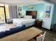 Bright bedroom boasts a king-sized bed, turquoise walls, beach decor and a private balcony at 6900 N Ocean Blvd. # 915, Myrtle Beach, SC 29572