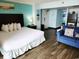 Bedroom featuring king size bed, blue walls, and a seating area at 6900 N Ocean Blvd. # 915, Myrtle Beach, SC 29572