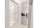 Bathroom featuring a glass shower door and view into the open-concept living and dining area at 698 Riverwalk Dr. # 304, Myrtle Beach, SC 29579