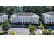Three-story condo building with white balconies, ample parking, and lush landscaping at 698 Riverwalk Dr. # 304, Myrtle Beach, SC 29579