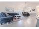 A living room shows a large blue sofa, hardwood floors, and a view to the kitchen at 698 Riverwalk Dr. # 304, Myrtle Beach, SC 29579