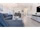 A living room shows a large blue sofa, hardwood floors, and a view to the kitchen at 698 Riverwalk Dr. # 304, Myrtle Beach, SC 29579
