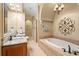 Luxurious bathroom with a soaking tub, double vanity with granite countertops, and elegant chandelier lighting at 7545 Ventura Ct., Myrtle Beach, SC 29572