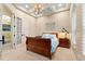 Well-lit bedroom with a wooden sleigh bed, blue accents, tray ceiling, and french doors for natural light at 7545 Ventura Ct., Myrtle Beach, SC 29572