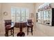 Charming breakfast nook featuring a round table, two chairs, shuttered windows, and decorative beach-themed elements at 7545 Ventura Ct., Myrtle Beach, SC 29572