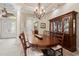 An elegant dining room with a chandelier, large wood table, display cabinet, and tiled floor at 7545 Ventura Ct., Myrtle Beach, SC 29572