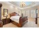Bright main bedroom featuring a wooden sleigh bed, tray ceiling, and plantation shutters on the windows at 7545 Ventura Ct., Myrtle Beach, SC 29572
