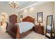 Elegant main bedroom featuring a wooden sleigh bed, ornate chandelier, and stylish bedside tables with lamps at 7545 Ventura Ct., Myrtle Beach, SC 29572