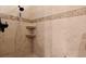 Modern tiled shower featuring a rainfall shower head, built-in shelves, and neutral earth tone color scheme at 7545 Ventura Ct., Myrtle Beach, SC 29572