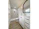 Bathroom featuring a vanity with brass hardware, an oval mirror, and a tiled shower at 7611 Coteswood Dr., Myrtle Beach, SC 29572