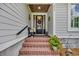 Inviting front porch with brick steps, seasonal wreath on the black door, and a cozy bench for relaxation at 816 Morrall Dr., North Myrtle Beach, SC 29582