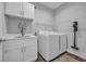 Functional laundry room boasts modern washer and dryer, basin sink and ample overhead cabinet space at 816 Morrall Dr., North Myrtle Beach, SC 29582