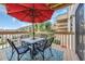 Outdoor dining on the balcony with table, chairs, and a striped umbrella at 9661 Shore Dr. # B7-29, Myrtle Beach, SC 29572