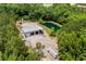 Aerial view of a pond, surrounded by garages, trucks, and lush greenery at 971 Mcnabb Rd., Loris, SC 29569