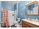 Bright blue bathroom boasts a shower-tub combo, wood vanity, and mirrored medicine cabinet at 971 Mcnabb Rd., Loris, SC 29569