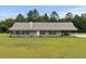 Charming ranch-style home with a covered front porch and attached carport, surrounded by a well-manicured lawn and mature trees at 971 Mcnabb Rd., Loris, SC 29569