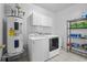 The laundry room offers modern appliances, storage cabinets, and shelving for organized convenience at 971 Mcnabb Rd., Loris, SC 29569