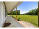 Inviting porch with stone accents and serene views of the sprawling green lawn and surrounding landscape at 971 Mcnabb Rd., Loris, SC 29569