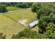 Aerial view of fenced acreage with barn, home and surrounding woodland, a tranquil setting at 971A Mcnabb Rd., Loris, SC 29569