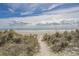 Scenic beach view with sandy dunes, grassy path, and beautiful horizon, ideal for relaxing strolls at 971A Mcnabb Rd., Loris, SC 29569
