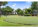 Community putting green with a pond, flags, manicured landscaping, and mature trees at 9776 Leyland Dr. # 2, Myrtle Beach, SC 29572