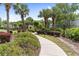 Sidewalk leading to community amenities surrounded by colorful landscaping and mature palm trees at 9776 Leyland Dr. # 2, Myrtle Beach, SC 29572